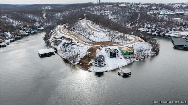 snowy aerial view featuring a water view