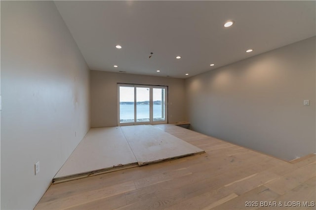 empty room with a water view and light hardwood / wood-style flooring