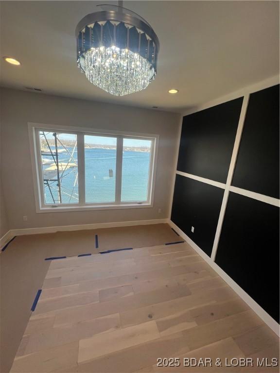 empty room featuring baseboards, wood finished floors, and recessed lighting