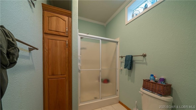 bathroom with tile patterned floors, a shower with shower door, ornamental molding, and toilet