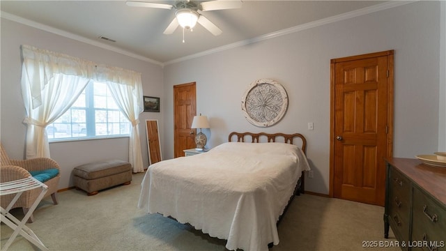 bedroom featuring ornamental molding, light colored carpet, and ceiling fan