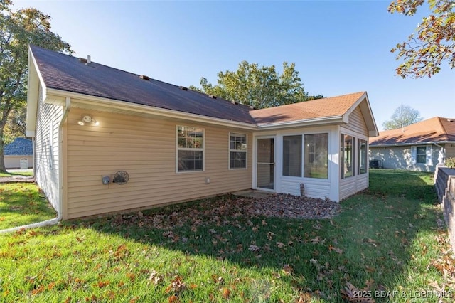 back of property featuring a sunroom and a yard