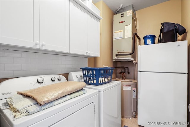 clothes washing area featuring cabinets and separate washer and dryer