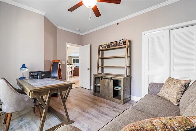 office space featuring light hardwood / wood-style flooring, ornamental molding, and ceiling fan