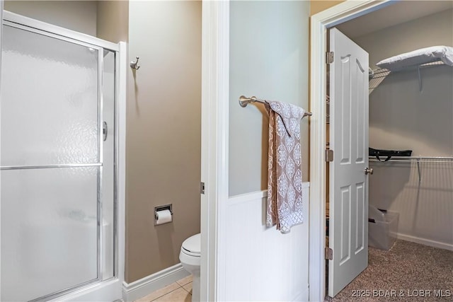 bathroom with a shower with door and toilet