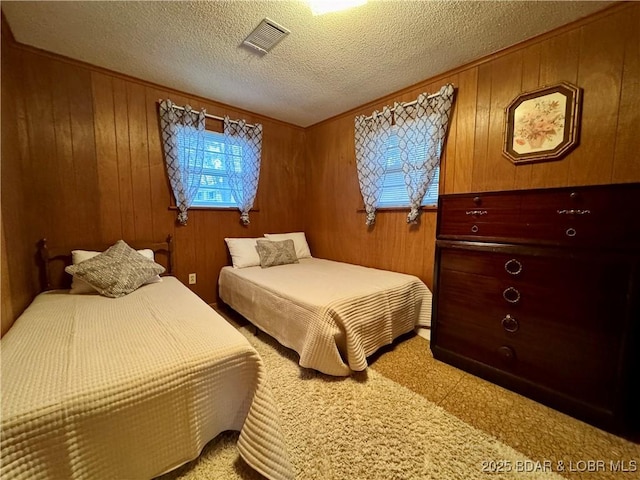 bedroom featuring a textured ceiling and wood walls