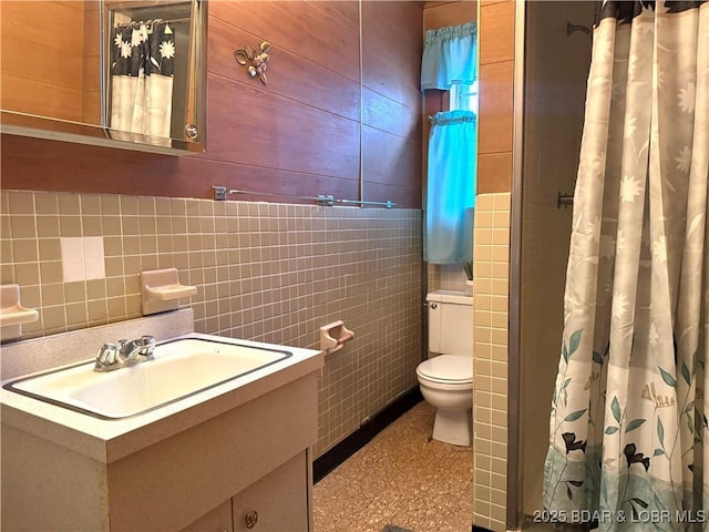 bathroom featuring a shower with curtain, vanity, tile walls, and toilet