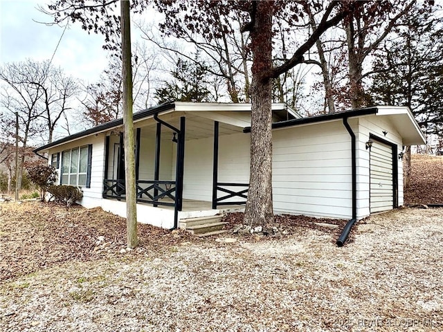 view of property exterior with a porch and a garage