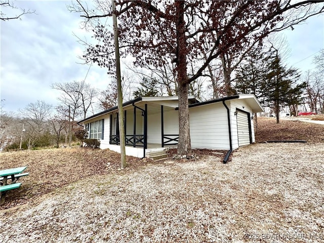 view of side of property featuring a garage and a porch