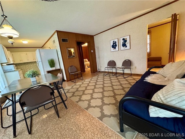 living room with crown molding and wooden walls