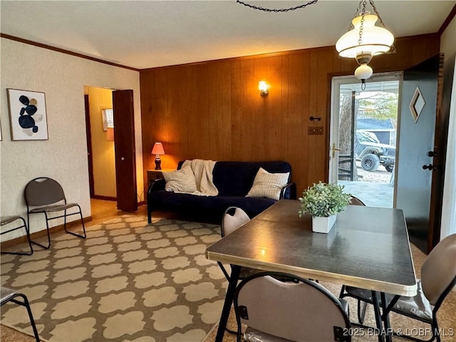 dining space with crown molding and wooden walls