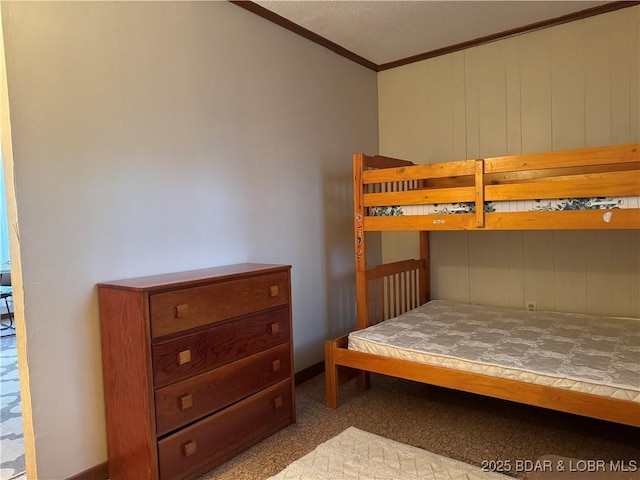 bedroom featuring crown molding and wood walls