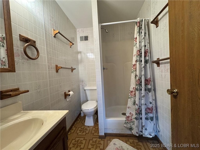 bathroom featuring vanity, tile walls, curtained shower, and toilet