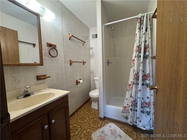 bathroom featuring a shower with curtain, vanity, toilet, and tile walls