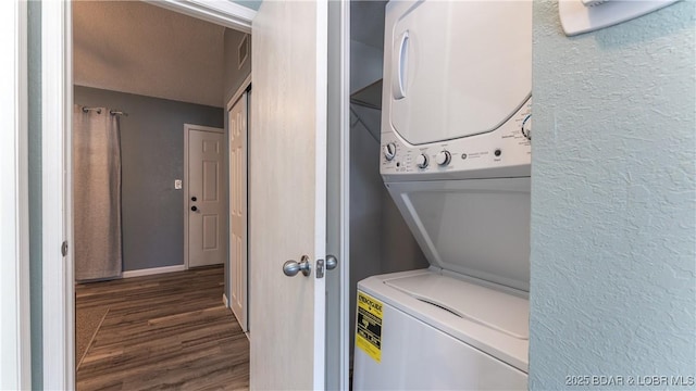 washroom featuring dark wood-type flooring and stacked washer / drying machine