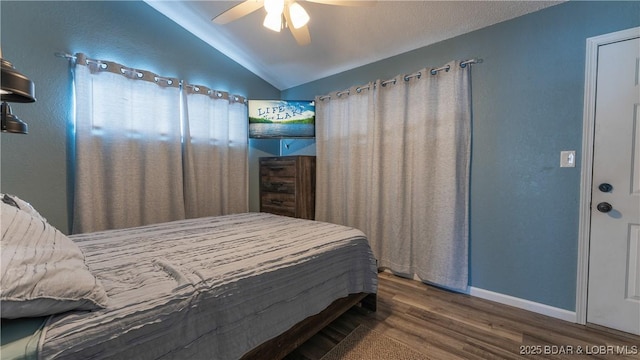 bedroom with lofted ceiling, dark hardwood / wood-style floors, and ceiling fan