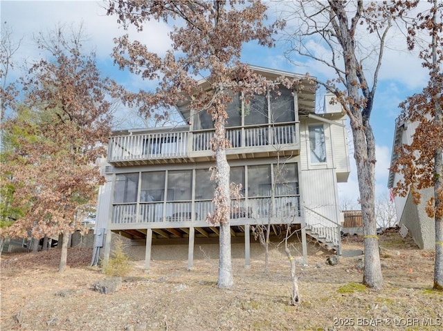 rear view of property featuring a sunroom