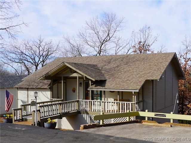 view of front of property with covered porch and a shingled roof