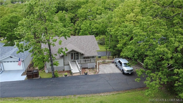 161 Lubbers Quarters, Osage Beach, MO 65065 - view of front of property with asphalt driveway, roof with shingles, a wooded view, and covered porch