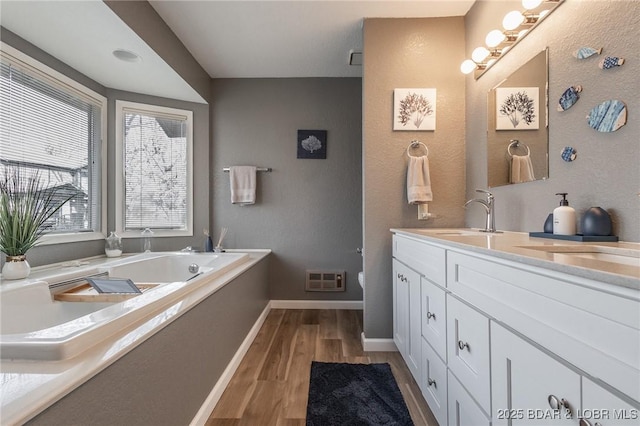 bathroom with vanity, a bathing tub, and hardwood / wood-style floors