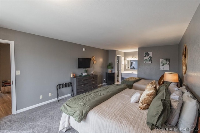 bedroom with ensuite bathroom and carpet