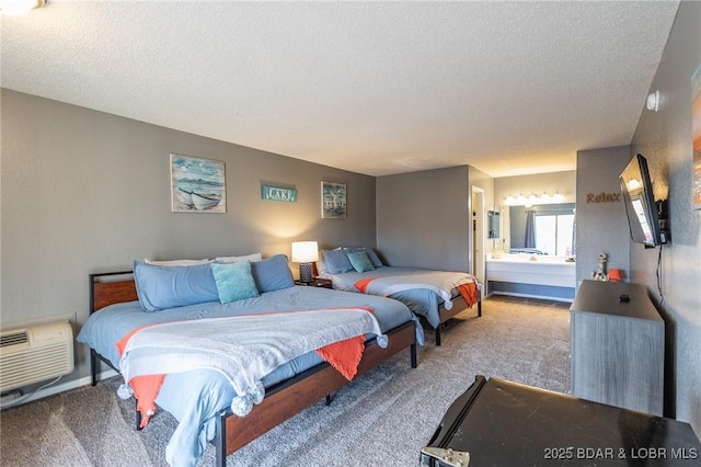 bedroom with a wall unit AC, ensuite bathroom, carpet, and a textured ceiling