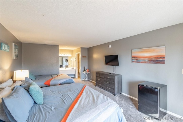 bedroom featuring ensuite bathroom, light carpet, and a textured ceiling