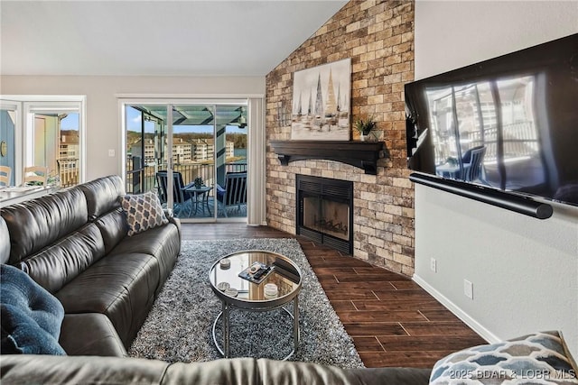 living room featuring vaulted ceiling and a large fireplace