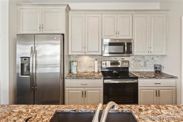 kitchen featuring tasteful backsplash, appliances with stainless steel finishes, and white cabinets