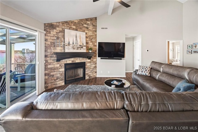 living room featuring hardwood / wood-style floors, high vaulted ceiling, a brick fireplace, and ceiling fan