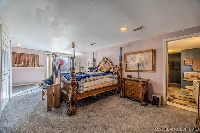 bedroom with ensuite bath, visible vents, and carpet