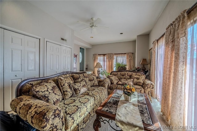 living room featuring ceiling fan and visible vents