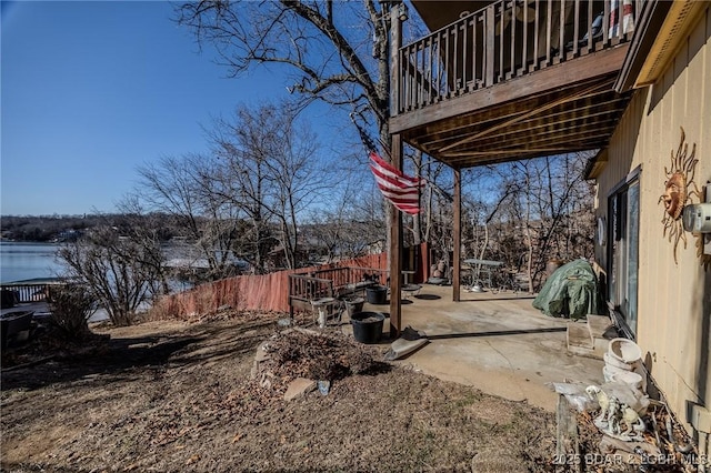 view of yard featuring a balcony, fence, and a patio