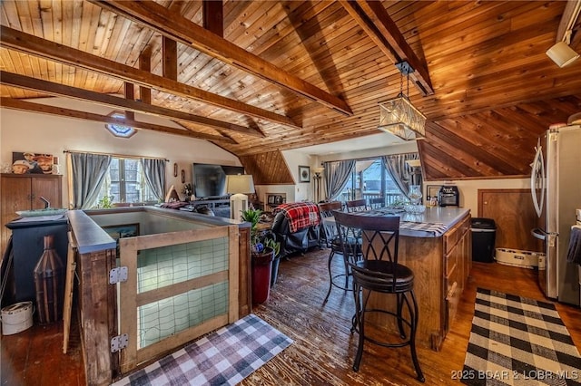 kitchen with wood ceiling, a center island, lofted ceiling with beams, stainless steel refrigerator, and dark hardwood / wood-style flooring