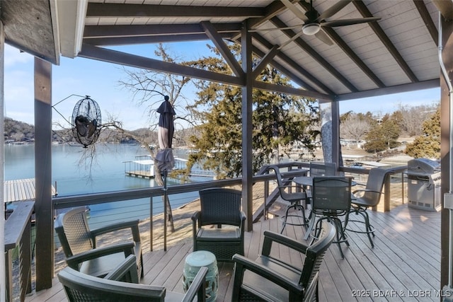 wooden terrace featuring a water view, grilling area, and ceiling fan