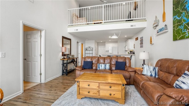 living room featuring light hardwood / wood-style flooring and a high ceiling