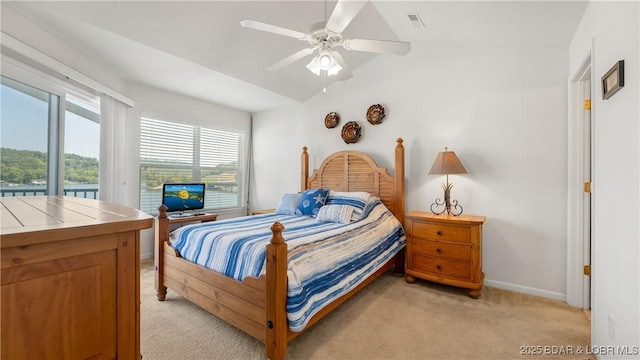 carpeted bedroom with ceiling fan, vaulted ceiling, and multiple windows