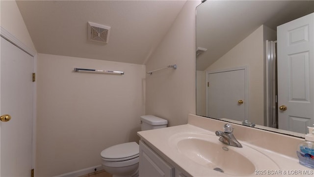 bathroom featuring lofted ceiling, vanity, and toilet