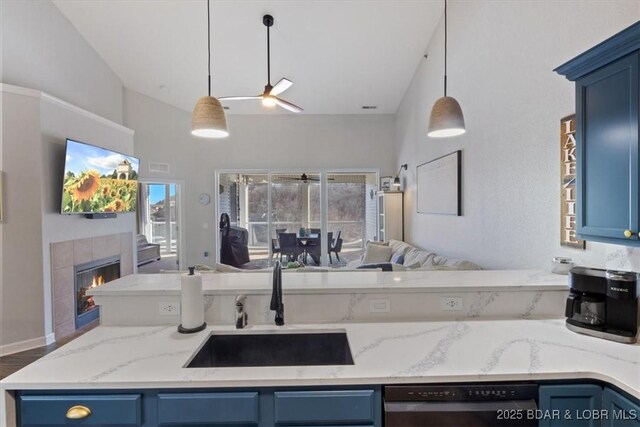 kitchen with a fireplace, decorative light fixtures, blue cabinets, black dishwasher, and sink