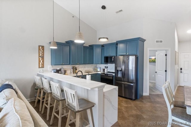 kitchen with blue cabinetry, a kitchen bar, appliances with stainless steel finishes, kitchen peninsula, and backsplash