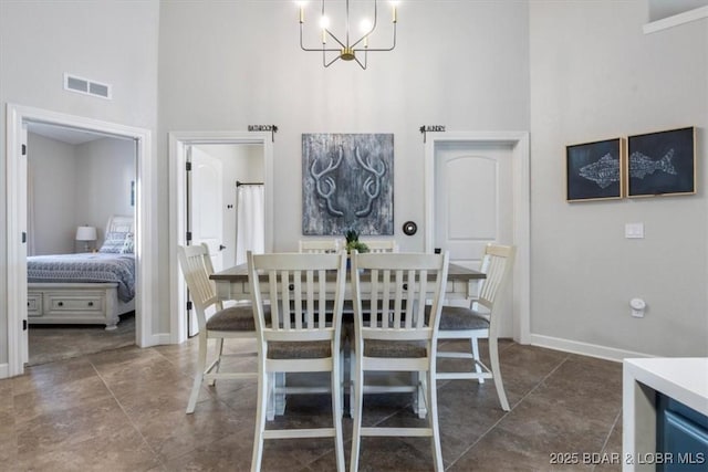 dining room featuring an inviting chandelier and a towering ceiling