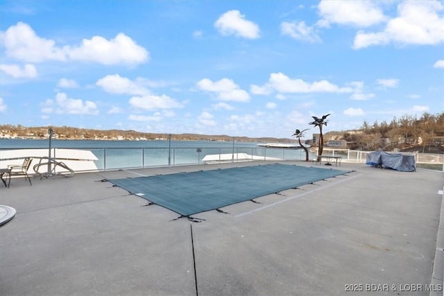 view of swimming pool featuring a patio and a water view