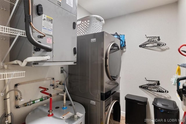 utility room with stacked washer and dryer and water heater