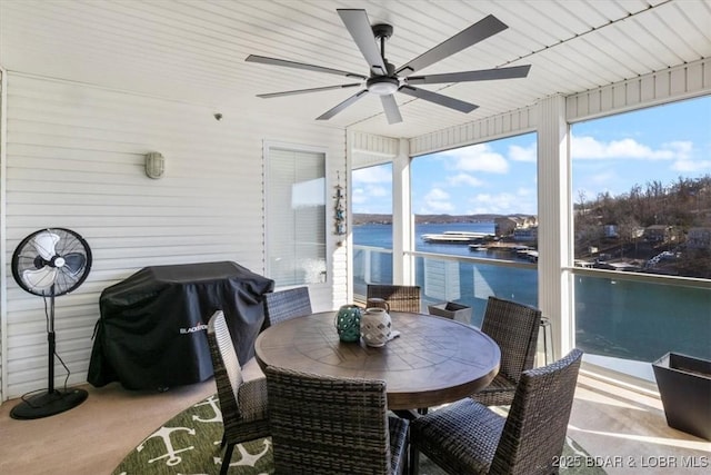 sunroom featuring a water view and ceiling fan