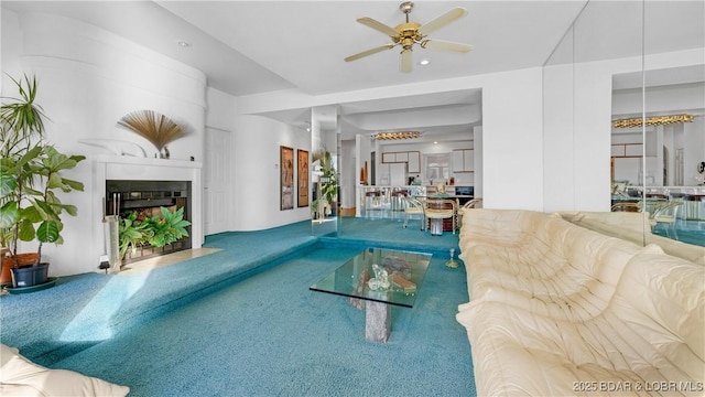 view of swimming pool featuring a large fireplace and ceiling fan