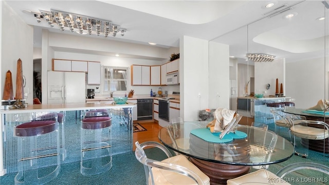 kitchen featuring white cabinetry, white appliances, and pendant lighting