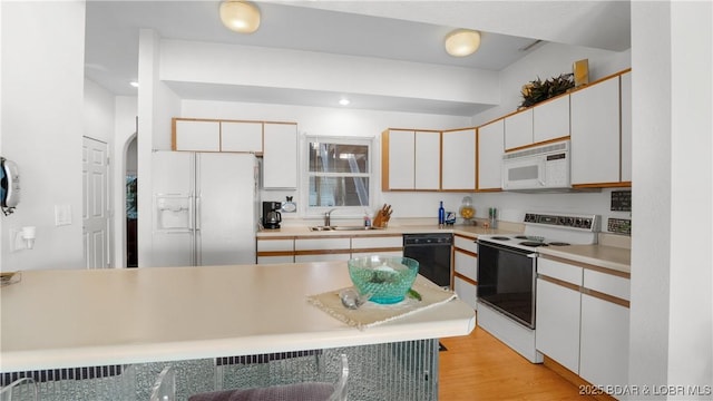 757 Malibu Rd Unit A101, Osage Beach, MO 65065 - kitchen with white appliances, a sink, light countertops, light wood-style flooring, and arched walkways