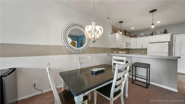 dining room with an inviting chandelier and dark carpet