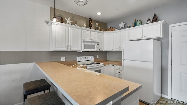 kitchen featuring sink, white appliances, white cabinets, decorative light fixtures, and kitchen peninsula