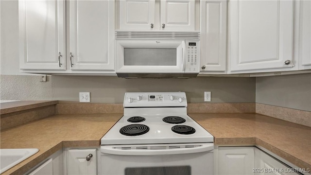 kitchen featuring white cabinetry and white appliances